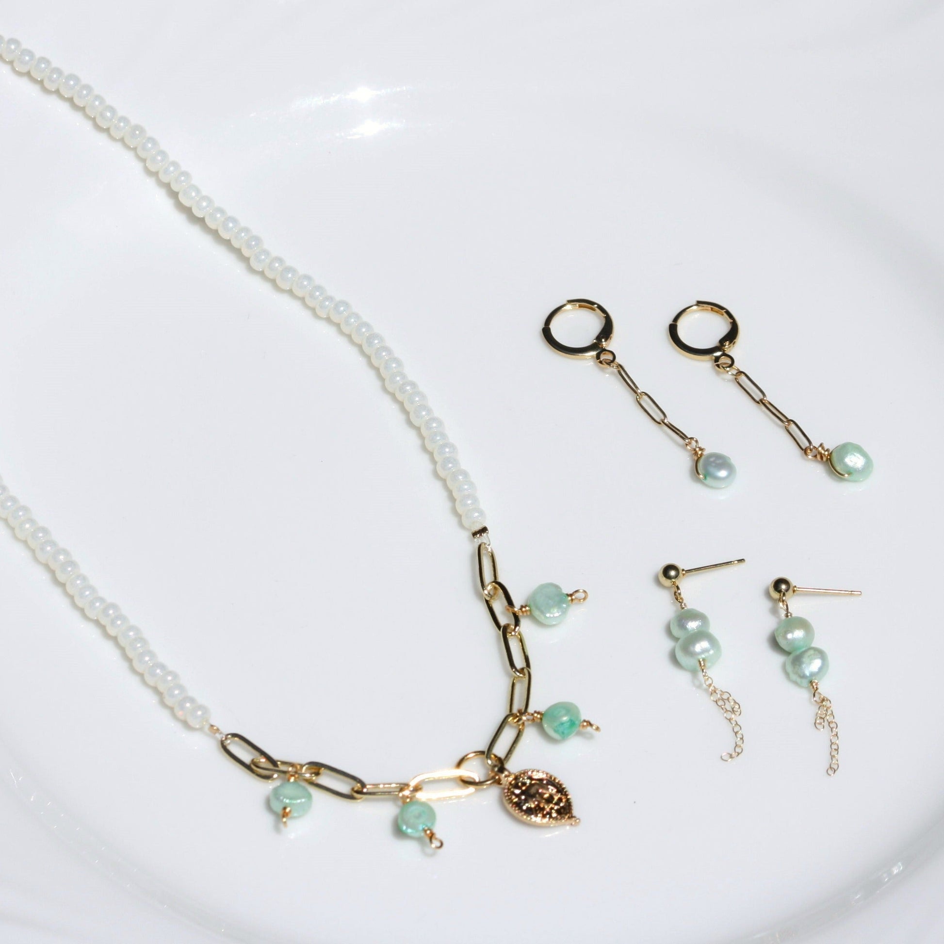 Jewelry set featuring blue pearls and gold. 