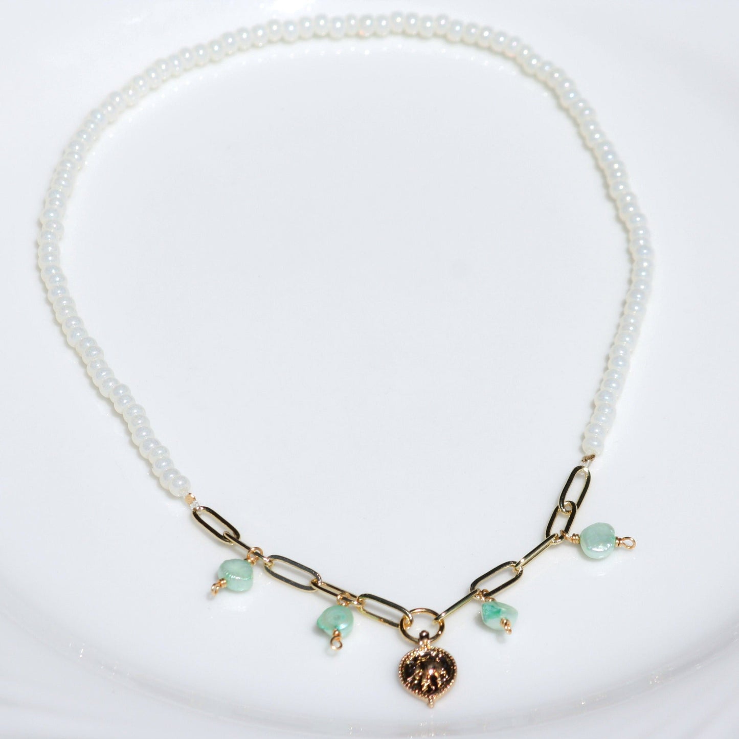 Stretch necklace featuring seed bead in opaque white pearl.