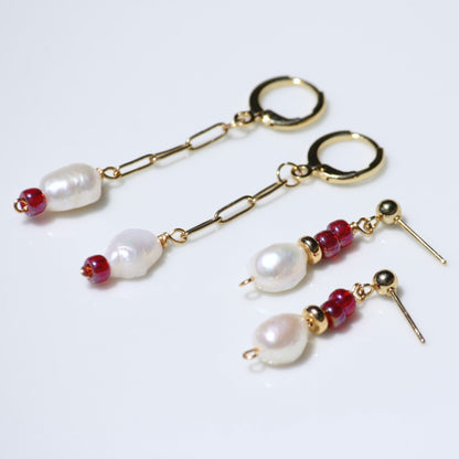 Close up of earring stack featuring pearls and ruby red beads.