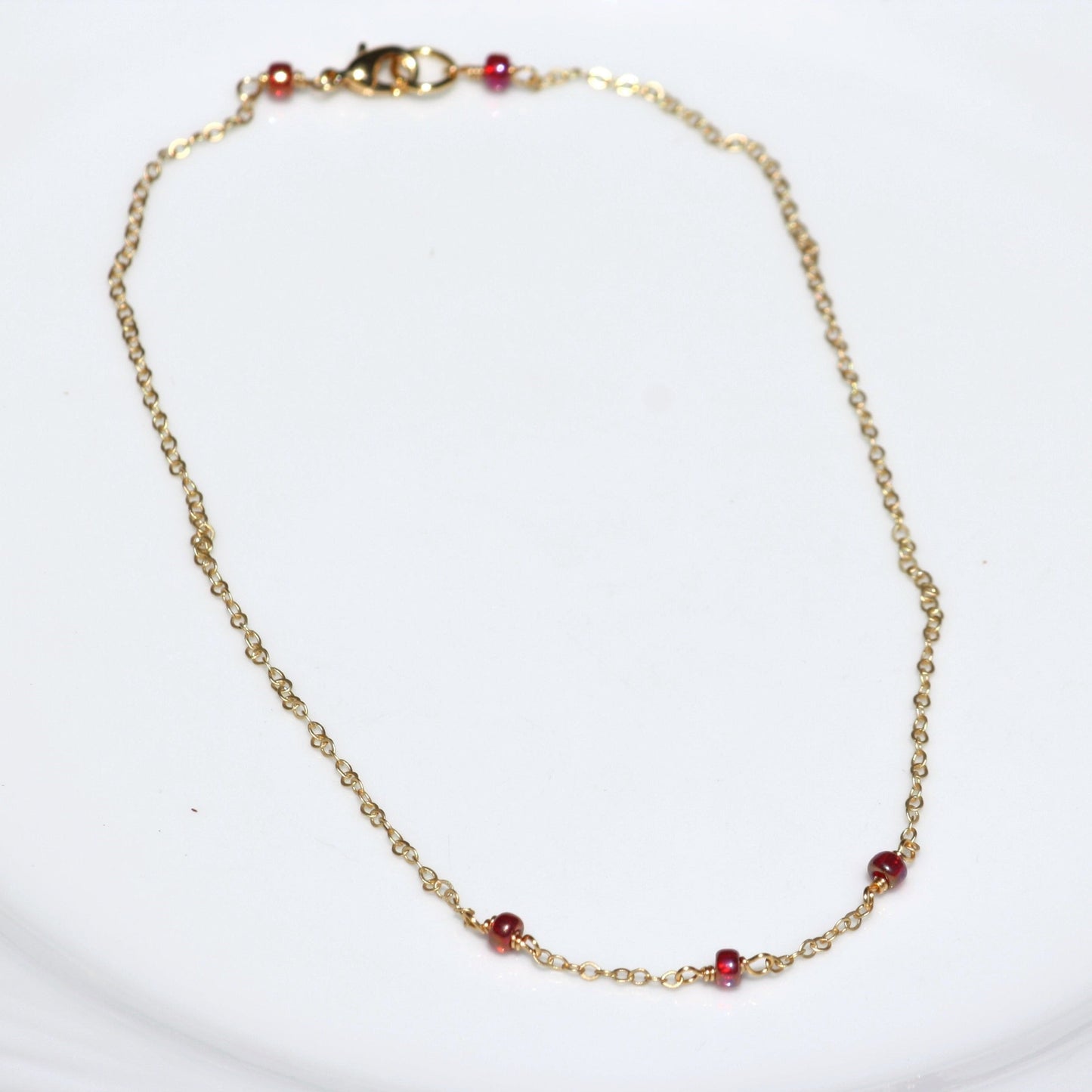 Photo of simple chain necklace with red ruby seed beads.