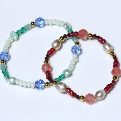 Close up of stretch bracelets with pink and blue/green beads.