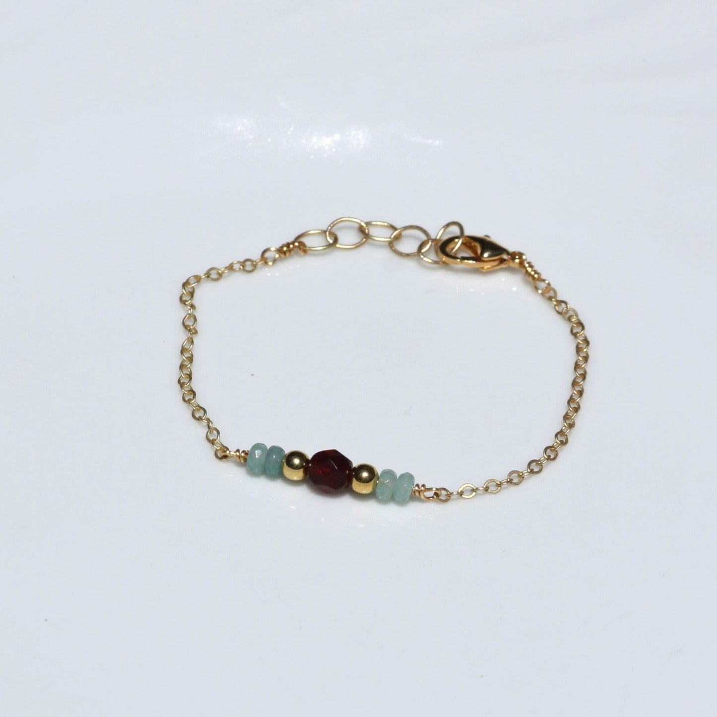 Chain bracelet with ruby and blue accents.