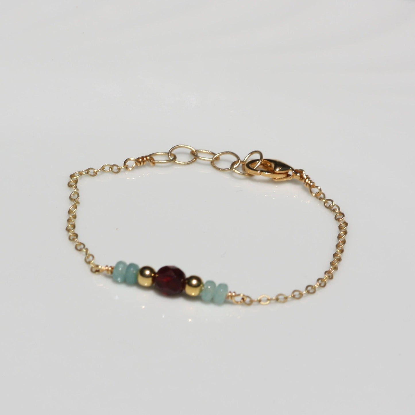 Handmade bracelet with gold chain and beaded detail.